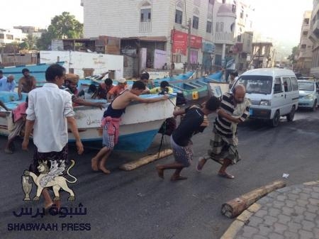 صيادو عدن يسحبون قواربهم من البحر بعد إرتفاع الموج (صيرة)